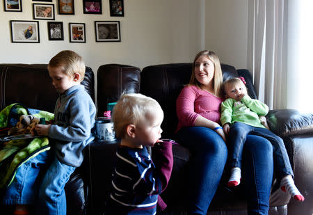 Amber Oakley sits with her children in their new mold free home in Oklahoma City, Oklahoma, U.S. November 26, 2018. REUTERS/Nick Oxford