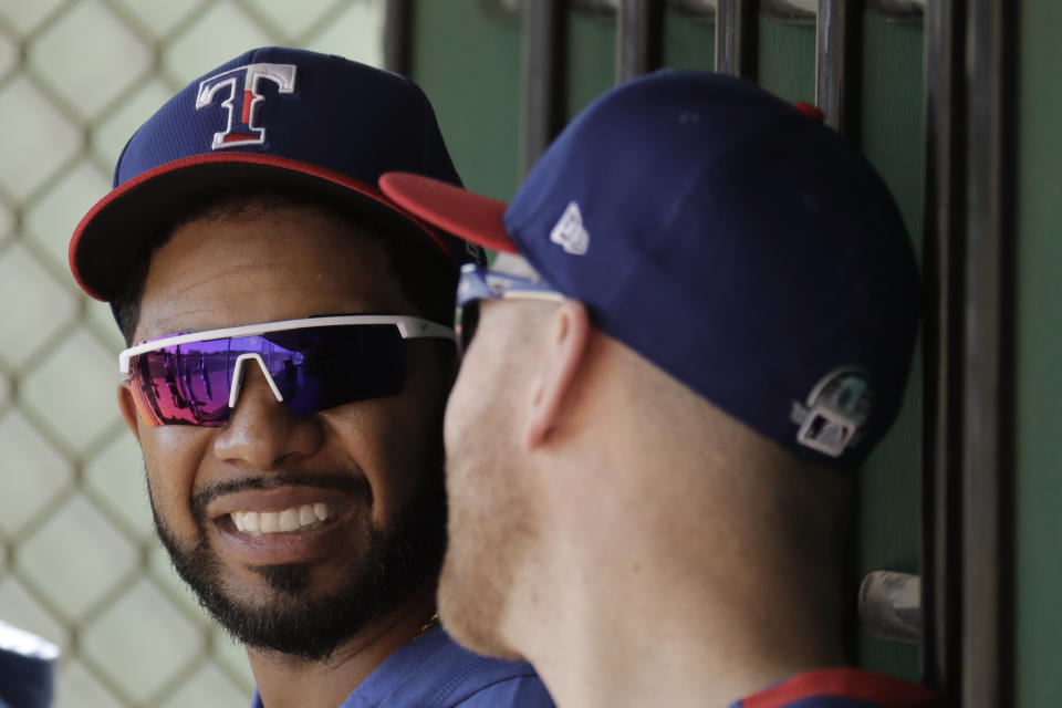 Texas Rangers' Elvis Andrus, left, talks with Todd Frazier during spring training baseball practice Monday, Feb. 17, 2020, in Surprise, Ariz. (AP Photo/Charlie Riedel)