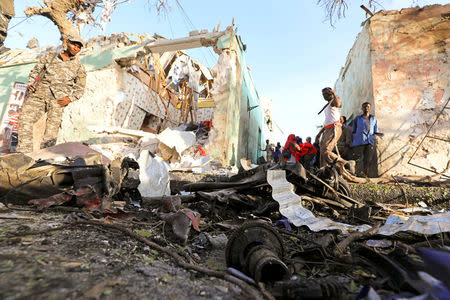 Somali security forces and civilians assess the damage at the scene of an explosion outside Weheliye Hotel in Maka al Mukarama street in Mogadishu, Somalia March 22, 2018. REUTERS/Feisal Omar
