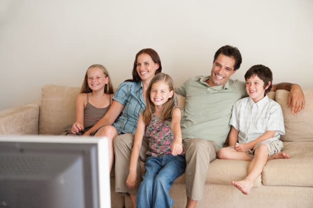 A young family watching television