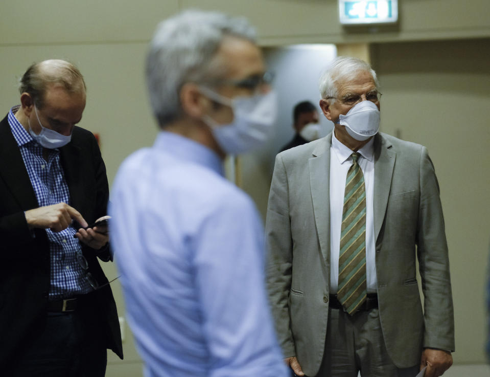 European Union foreign policy chief Josep Borrell, right, wears a mouth mask after addressing a video press conference at the conclusion of a video conference of EU foreign affairs ministers in Brussels, Wednesday, April 22, 2020. (Olivier Hoslet, Pool Photo via AP)