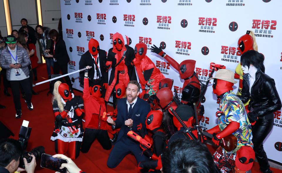 Ryan Reynolds surrounded by people dressed up as his character "Deadpool" in Beijing, China