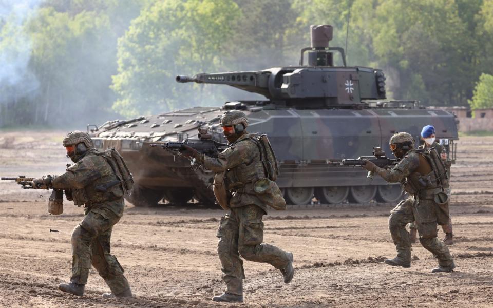 Bundeswehr soldiers run past a Puma mechanized infantry combat vehicle during a demonstration of capabilities by the Panzerlehrbrigade 9 tank training brigade on June 02, 2021 - Sean Gallup/Getty