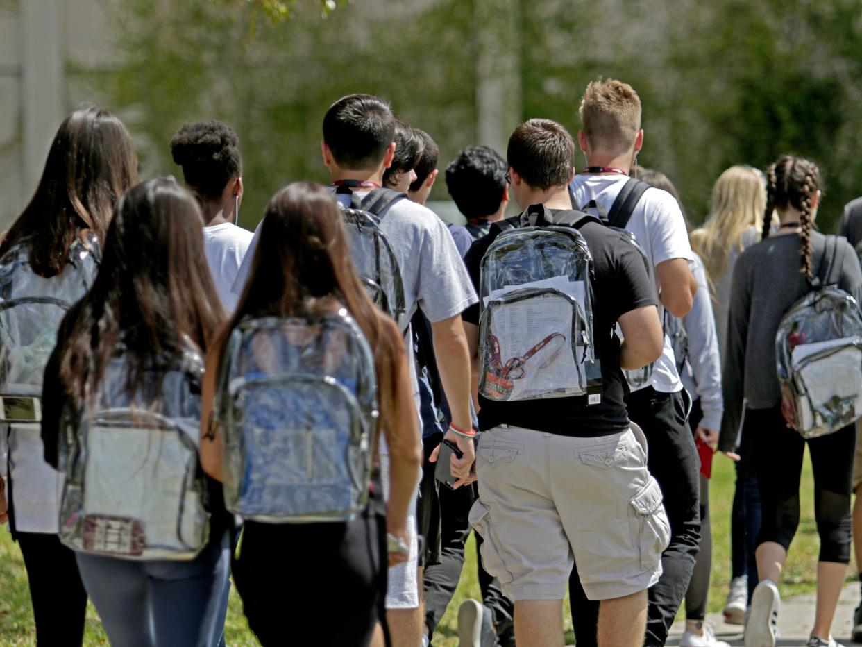 Students wear clear backpacks outside of Marjory Stoneman Douglas High School in Parkland, Fla. on Monday, April 2, 2018.