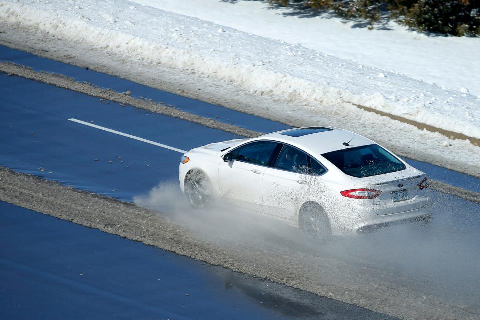 Car drives though water from melting snow on W Hefner Road in Oklahoma City after a winter storm, Friday, Feb. 4, 2022. 