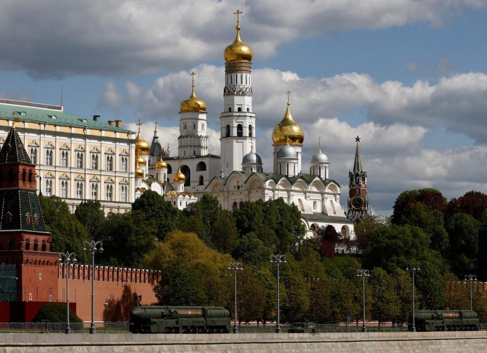 Armoured vehicles drive past the Kremlin wall after a military parade on Victory Day, with an empty sky, on May 9, 2023.