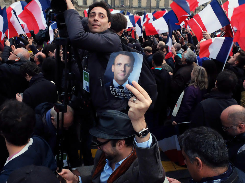 Man holding up photo of Emmanual Macron