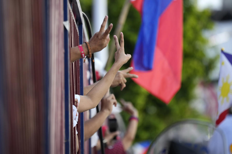 Supporters of Ferdinand "Bongbong" Marcos Jr. flash the victory sign as they celebrate outside his headquarters in Mandaluyong, Philippines on Tuesday May 10, 2022. Marcos Jr.'s apparent landslide victory in the Philippine presidential election is giving rise to immediate concerns about a further erosion of democracy in the region, and could complicate American efforts to blunt growing Chinese influence and power in the Pacific. (AP Photo/Aaron Favila)