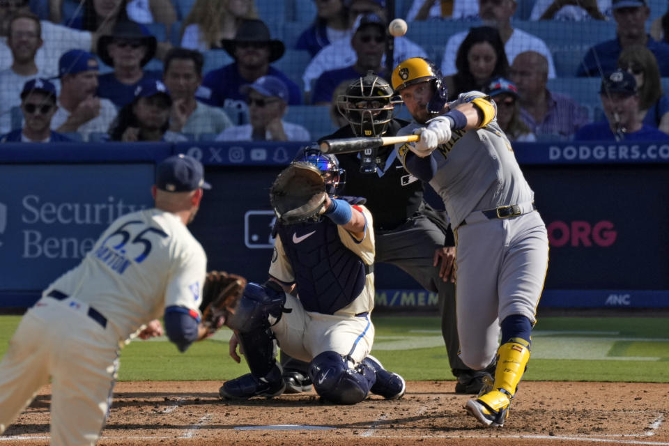 Milwaukee Brewers' Rhys Hoskins, right, hits a solo home run as Los Angeles Dodgers starting pitcher James Paxton, left, and catcher Will Smith, second from left, watch along with home plate umpire Edwin Moscoso during the fourth inning of a baseball game Saturday, July 6, 2024, in Los Angeles. (AP Photo/Mark J. Terrill)