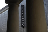 The Debenhams name is displayed between the pillars of another building at the Debenhams flagship department store on a side street off Oxford Street, during England's second coronavirus lockdown in London, Tuesday, Dec. 1, 2020. In another dark day for the British retailing industry, Debenhams said Tuesday it will start liquidating its business after a potential buyer of the company pulled out, a move that looks like it will cost 12,000 workers their jobs. (AP Photo/Matt Dunham)