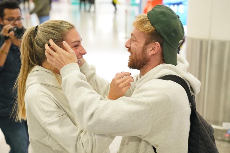 Sam Thompson greeted by Zara McDermott as he arrives in London after I'm a Celeb victory (PA)