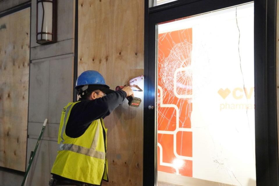 A worker boarding up windows at a Manhattan CVS where a shoplifter attacked an employee with a hammer. Christopher Sadowski