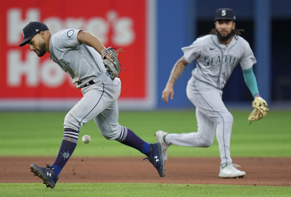 Seattle Mariners second baseman Abraham Toro (13) misses the ball on a hit by Toronto Blue Jays catcher Danny Jansen during the fourth inning of a baseball game in Toronto, Monday, May 16, 2022. (Nathan Denette/The Canadian Press via AP)