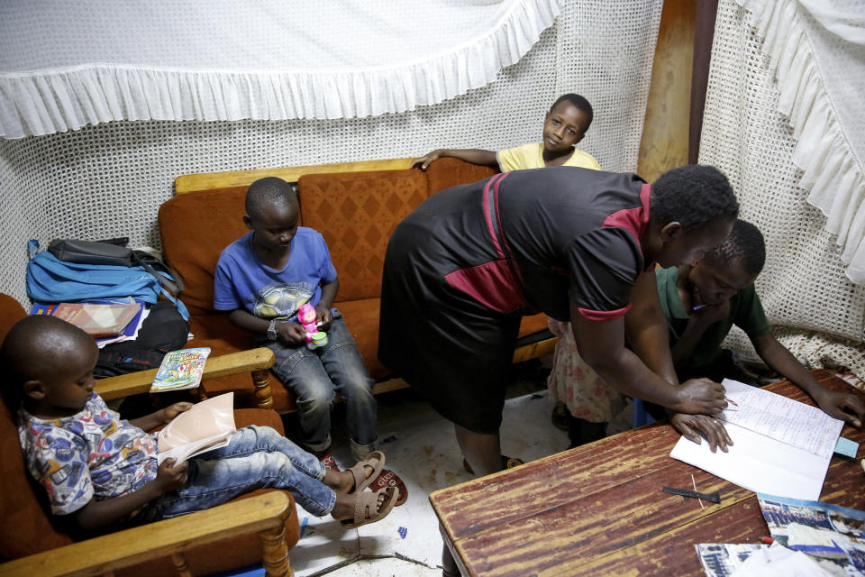 Nancy Andeka, 45, teaches hers and a neighbor's children at home as schools have been closed due to the spread of the new coronavirus, in the Kibera slum, or informal settlement, of Nairobi, Kenya Thursday, April 2, 2020. The new coronavirus causes mild or moderate symptoms for most people, but for some, especially older adults and people with existing health problems, it can cause more severe illness or death. (AP Photo/Brian Inganga)