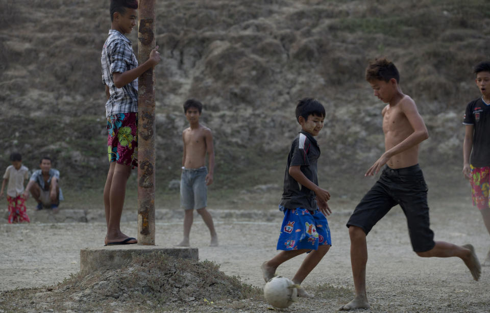 In this April 4, 2014 photo, children play soccer around a pole indicating the water level in dried-up reservoir in Dala, suburbs of Yangon, Myanmar. Residents of Dala relay on natural fresh-water ponds for water, but during Myanmar's the annual dry season in April and May, there is only so much to go around.(AP Photo/Gemunu Amarasinghe)