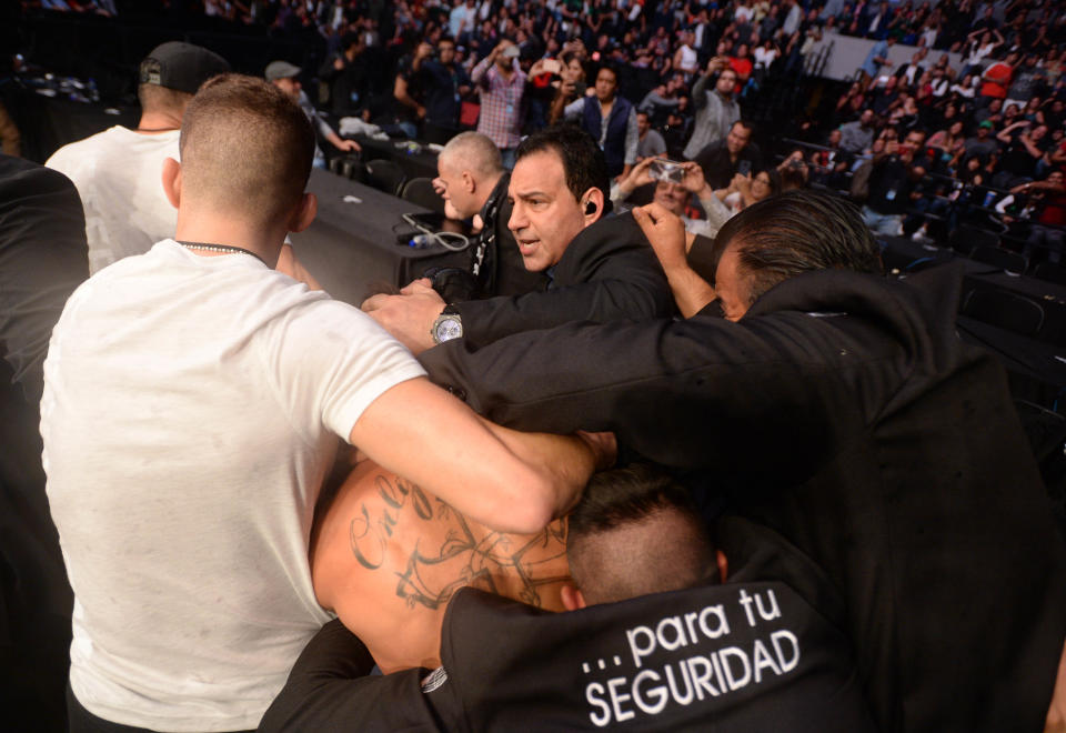 Sep 21, 2019; Mexico City, MEX; Jeremy Stephens (blue gloves) is escorted by security out of the octagon after his fight against Yair Rodriguez (red gloves) ended after being poked in the eye during UFC Fight Night at Mexico City Arena. Mandatory Credit: Orlando Ramirez-USA TODAY Sports