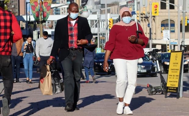 People wearing masks walk through downtown Ottawa on Sept. 26, 2021, during the fourth wave of the COVID-19 pandemic. (Trevor Pritchard/CBC - image credit)