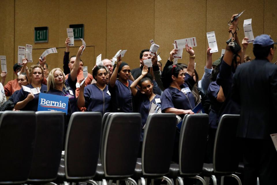 Casino workers hold up presidential preference cards as they support Democratic presidential candidate Sen. Bernie Sanders, I-Vt., during a presidential caucus at the Bellagio hotel-casino on Saturday.