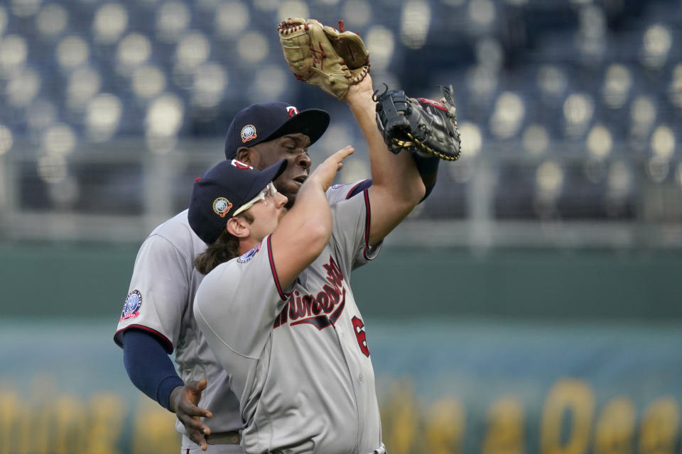 Minnesota Twins first baseman Miguel Sano, back, catches an infield fly over relief pitcher Randy Dobnak, front, during the third inning of a baseball game against the Kansas City Royals at Kauffman Stadium in Kansas City, Mo., Saturday, Aug. 22, 2020. (AP Photo/Orlin Wagner)