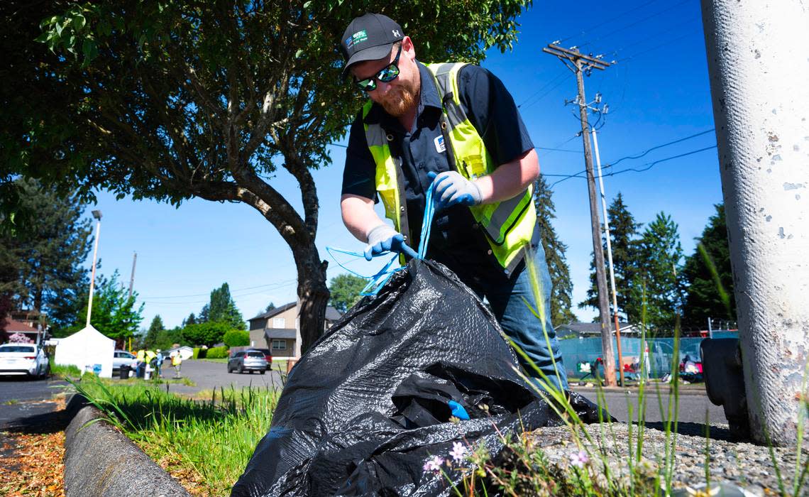 Tidy-Up Tacoma team member Justin MacFarlane picks up trash along South 88th Street in Tacoma, Washington, during a project with Litter Free 253 on Tuesday, May 14, 2024. Tony Overman/toverman@theolympian.com