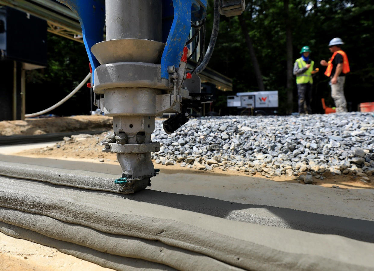 The printer head of a giant 3D printer begins laying cement for the foundation of a Habitat for Humanity home. (Consociate Media)