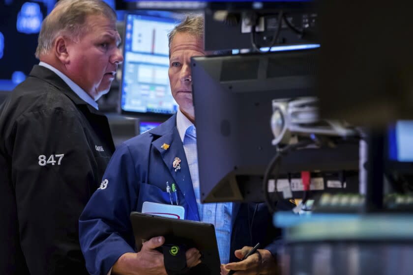 In this photo provided by the New York Stock Exchange, trader Robert Charmak, right, works on the floor, Tuesday, May 31, 2022. U.S. stocks are slipping in midday trading on Tuesday, as Wall Street nears the end of a tumultuous month, bruised by worries about a possible recession, inflation and rising interest rates. (Courtney Crow/New York Stock Exchange via AP)