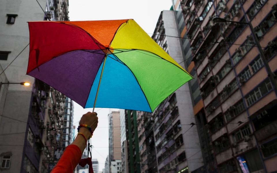 A participant holds a rainbow umbrella as he attends a Pride Parade in Hong Kong - REUTERS