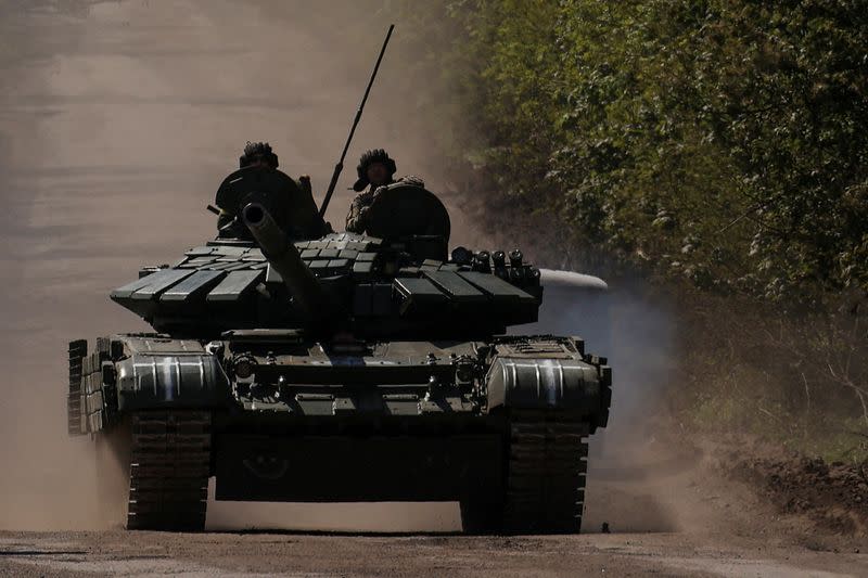 FILE PHOTO: Ukrainian servicemen ride atop of a tank on a road to the frontline town of Bakhmut