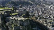 People enjoy the view atop of a castle in Gjirokastra town, southern Albania, Saturday, Feb. 6, 2021. Tourism had been flourishing in the UNESCO-protected city of Gjirokastra but the coronavirus pandemic brought an abrupt halt to that, with the prospects still bleak in 2021, and now residents are calling for government help to keep their businesses afloat. (AP Photo/Hektor Pustina)