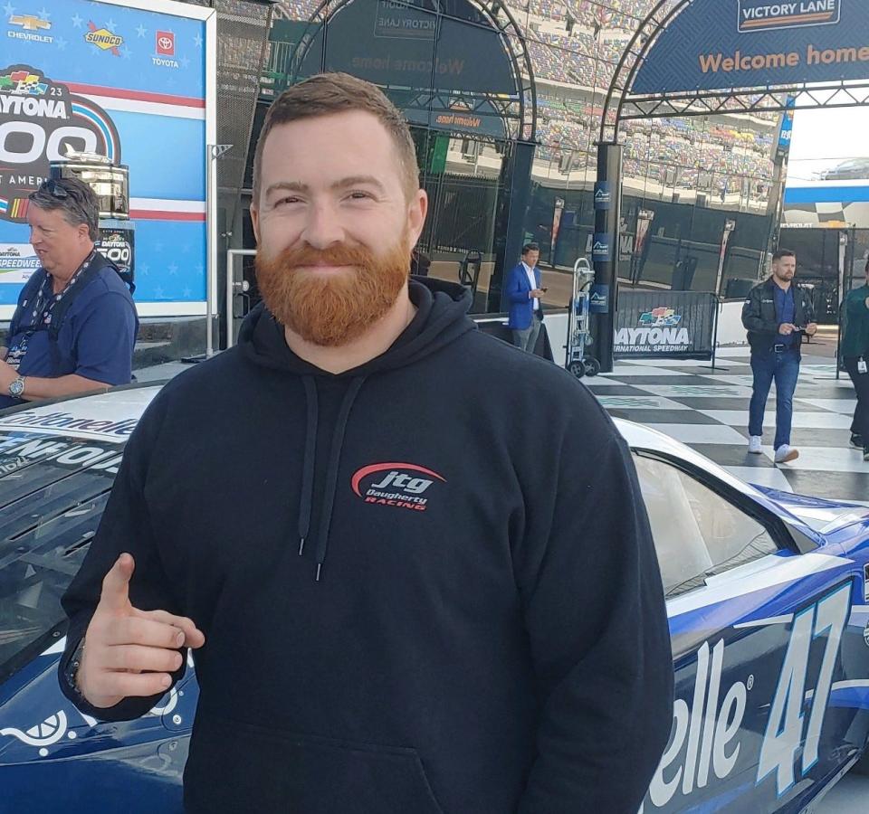 Zach Yager, a tire carrier on RIcky Stenhouse's pit crew, stands alongside the No. 47 Chevrolet that carried Stenhouse (seen here back-right) to Sunday's victory in the Daytona 500.