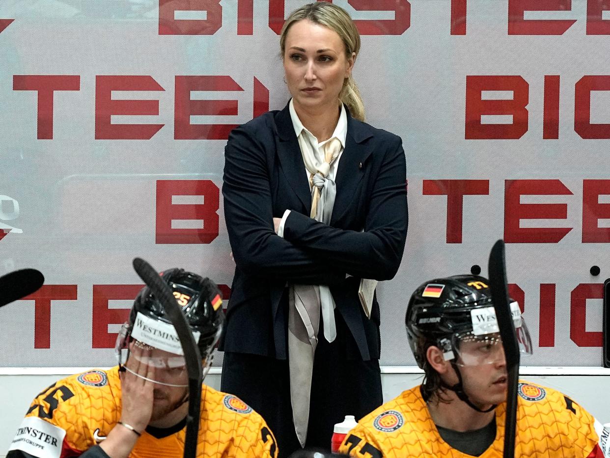 Germany's assistant coach Jessica Campbell stands behind players at the German bench during the group A Hockey World Championship match between France and Germany in Helsinki, Finland, Monday May 16, 2022.