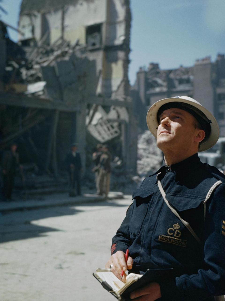 An Air Raid Precautions (ARP) warden inspecting damaged buildings in Holborn, London (Imperial War Museum )