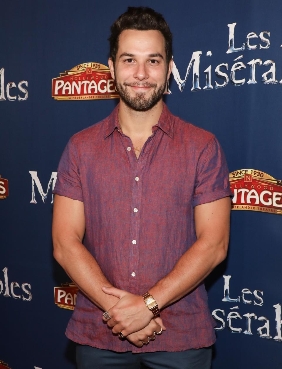 closeup of him with a beard wearing a short-sleeved button down