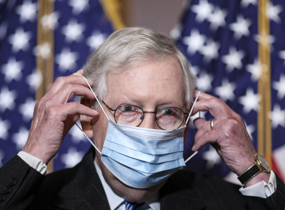 Senate Majority Leader Mitch McConnell of Ky., removes his face mask as he arrives for a news conference with other Senate Republicans on Capitol Hill in Washington, Tuesday, Dec. 15, 2020. (Tom Brenner/Pool via AP)