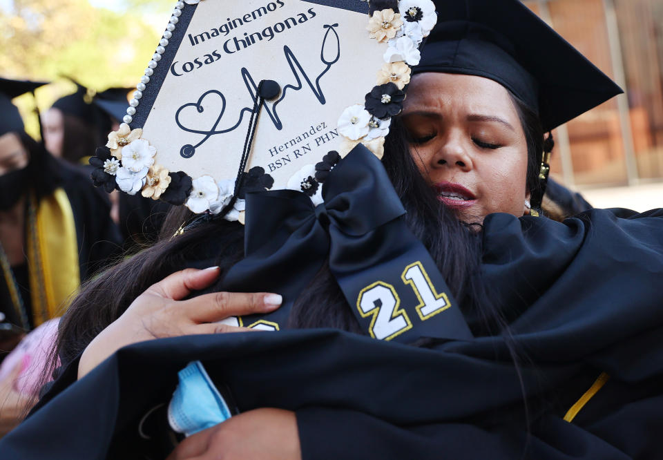Cal State Los Angeles graduate Maricris Trask hugs another graduate following their commencement ceremony on July 27, 2021 in Los Angeles. (Photo by Mario Tama/Getty Images)