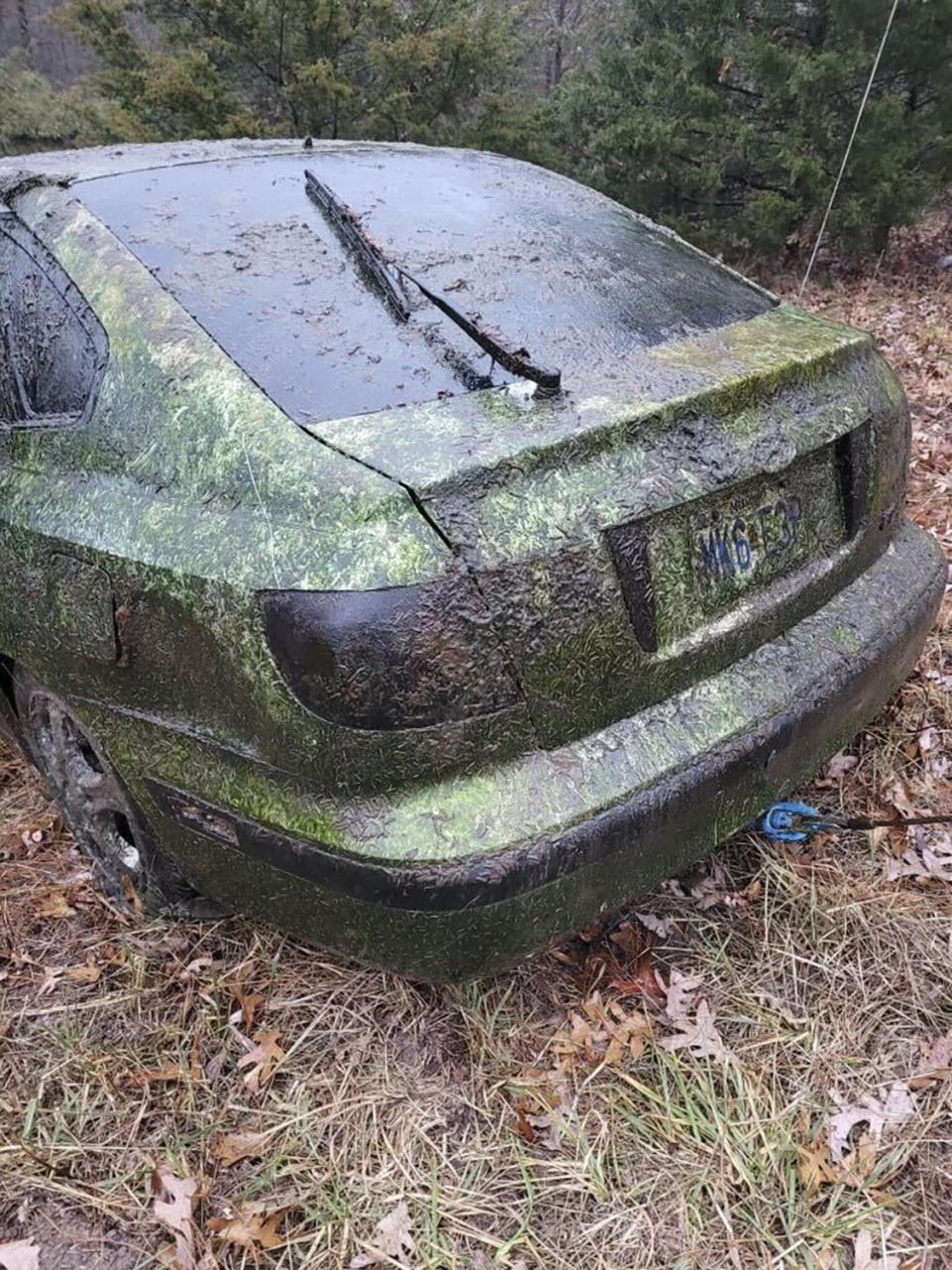 In a photo provided by the Camden County Sheriff's Office, a car is photographed on the ground outside after getting pulled out of a small pond south of Camdenton, Mo., city limits Dec. 17, 2023. Camden County deputies are once again investigating the disappearance of Donnie Erwin after dredging up his algae-encrusted vehicle in a tiny roadside drainage pond in December - almost exactly a decade after the 59-year-old went missing. (Detective Sgt Jeremiah Burnett/Camden County Sheriff’s Office via AP)