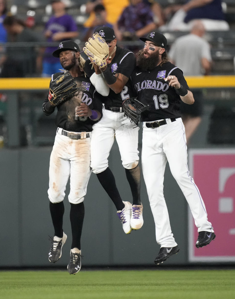 From left, Colorado Rockies left fielder Raimel Tapia, center fielder Yonathan Daza and right fielder Charlie Blackmon celebrate the team's 7-3 over the Milwaukee Brewers in a baseball game Thursday, June 17, 2021, in Denver. (AP Photo/David Zalubowski)