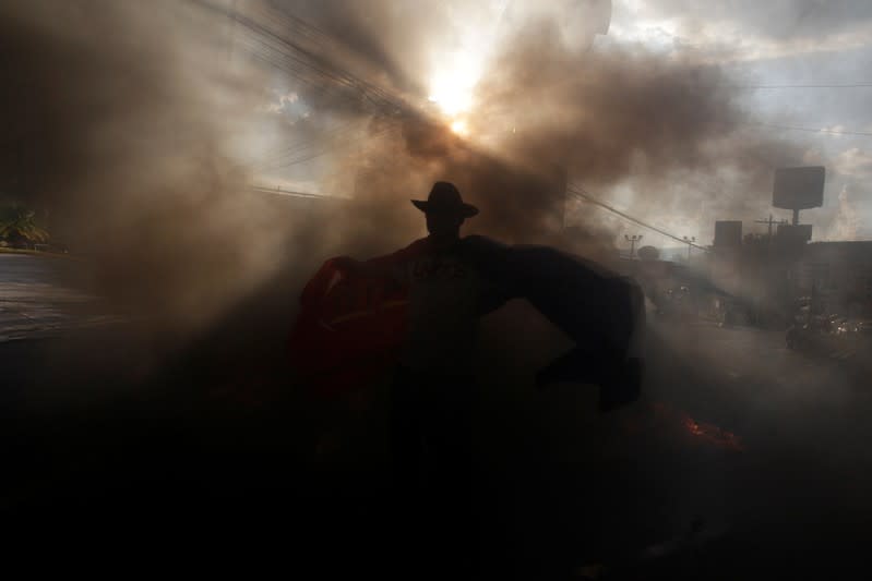 A demonstrator is seen amidst smog during a protest against the government of president Juan Orlando Hernandez, whose brother Juan Antonio "Tony" Hernandez was found guilty of U.S. drug trafficking charges, in Tegucigalpa