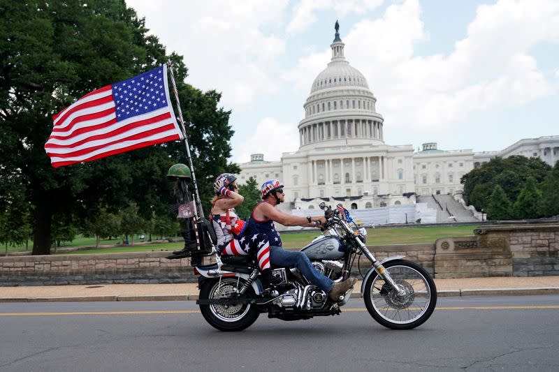 A couple dressed with the colours of the U.S. flag ride their motorcycle in front of the U.S. Capitol Building Washington