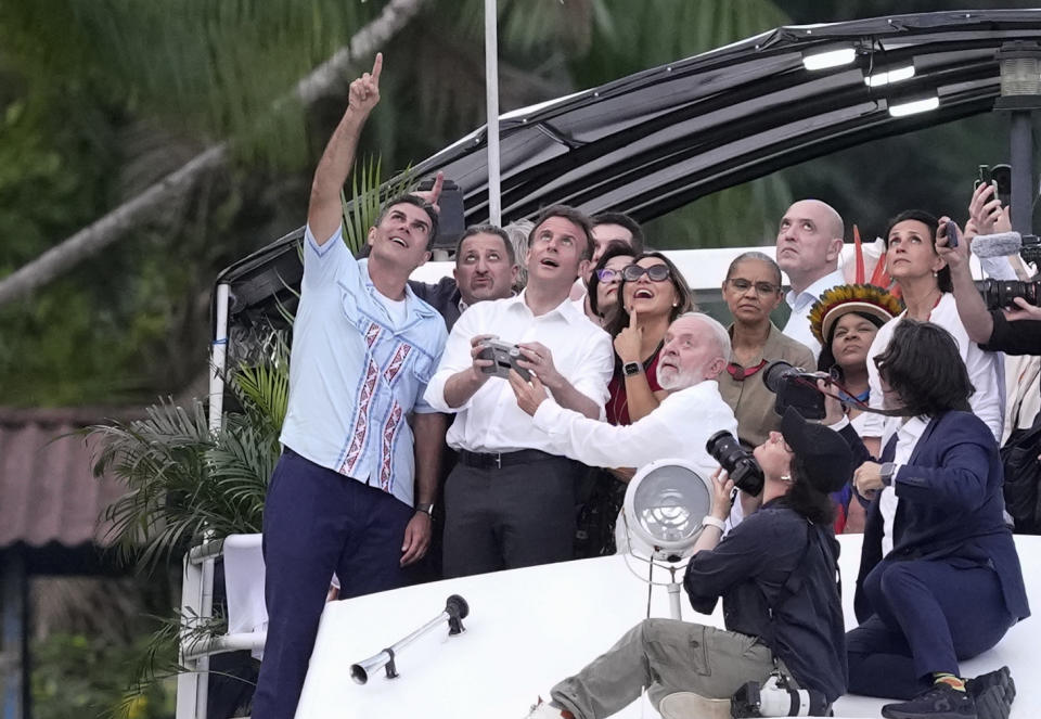 French President Emmanuel Macron, second left, flies a drone, accompanied by Brazil's President Luiz Inacio Lula da Silva, right center, first lady Rosangela da Silva, and Gov. Helder Barbalho, left, on Combu Island, near Belem, Para state, Brazil, Tuesday, March 26, 2024. Macron is on a three-day official visit to Brazil. (AP Photo/Eraldo Peres)