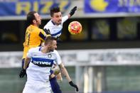 Inter Milan's defender Alex Telles (R) jumps for the ball with Verona's forward Giampaolo Pazzini during an Italian Serie A football match at the Bentegodi Stadium in Verona on Febrauary 7, 2016