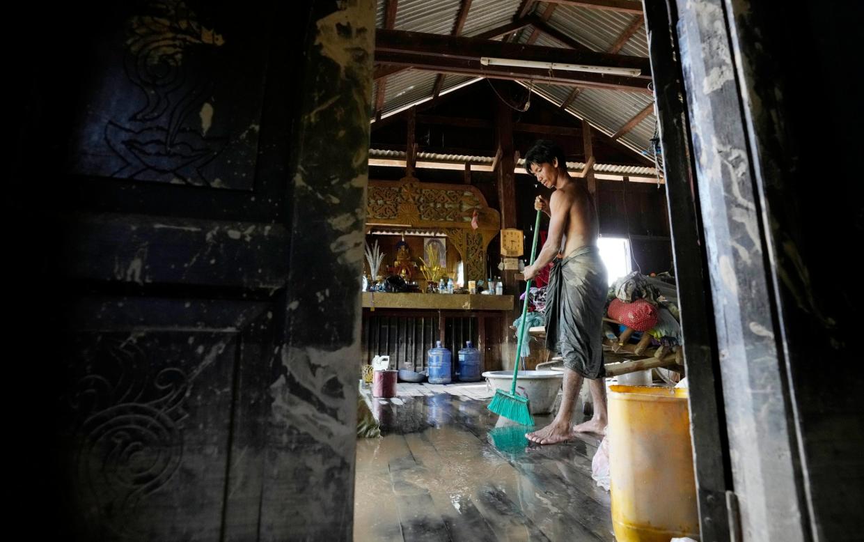 A man clears water from his home in Naypyitaw