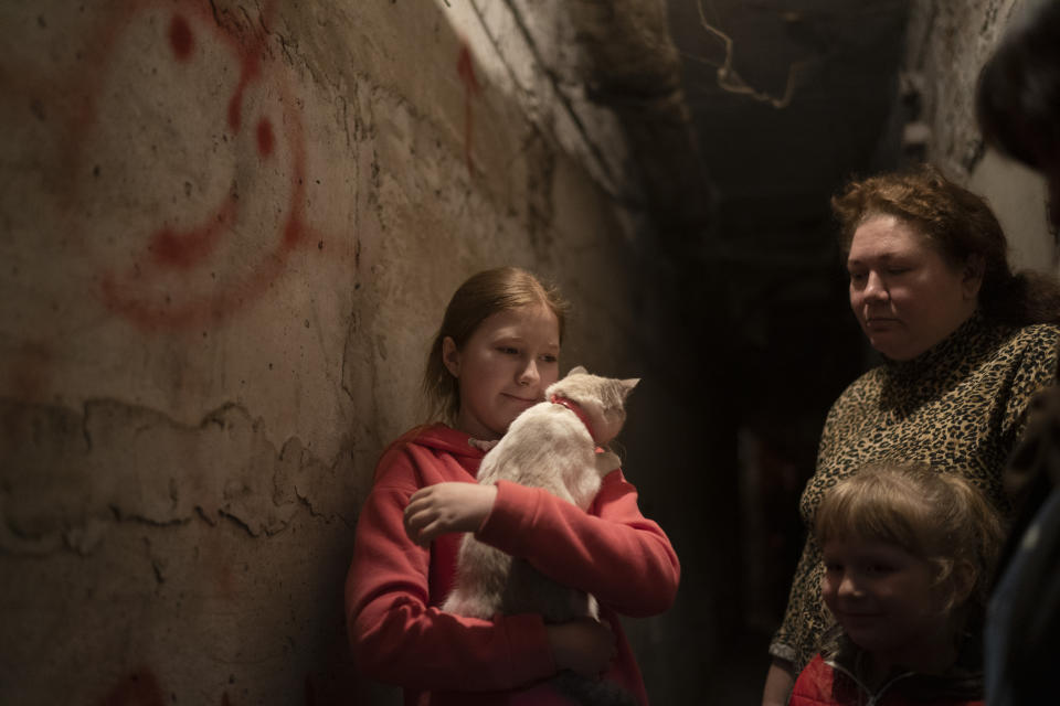 Elizabeth, 12, holds her cat as she takes shelter with her family inside the basement of a residential building during a Russian attack in Lyman, Ukraine, Tuesday, April 26, 2022. Russia pounded eastern and southern Ukraine on Tuesday as the U.S. promised to "keep moving heaven and earth" to get Kyiv the weapons it needs to repel the new offensive, despite Moscow's warnings that such support could trigger a wider war. (AP Photo/Leo Correa)