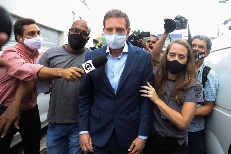 Rio de Janeiro's Mayor Marcelo Crivella is escorted by police officers after being detained