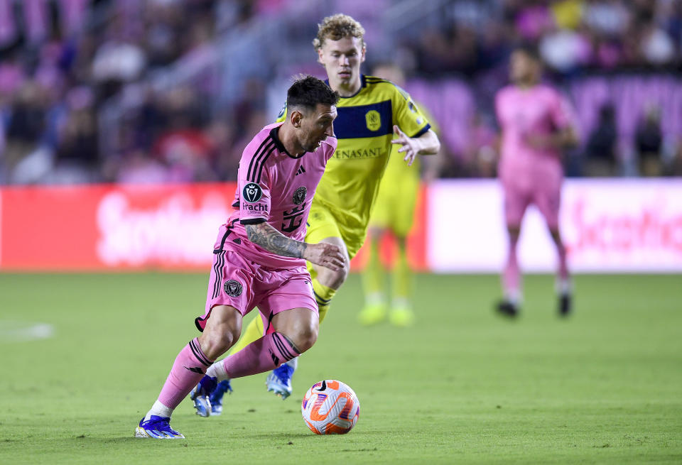 Inter Miami forward Lionel Messi dribbles past Nashville SC forward Jacob Shaffelburg during the first half of a CONCACAF Champions Cup soccer match, Wednesday, March 13, 2024, in Fort Lauderdale, Fla. (AP Photo/Michael Laughlin)