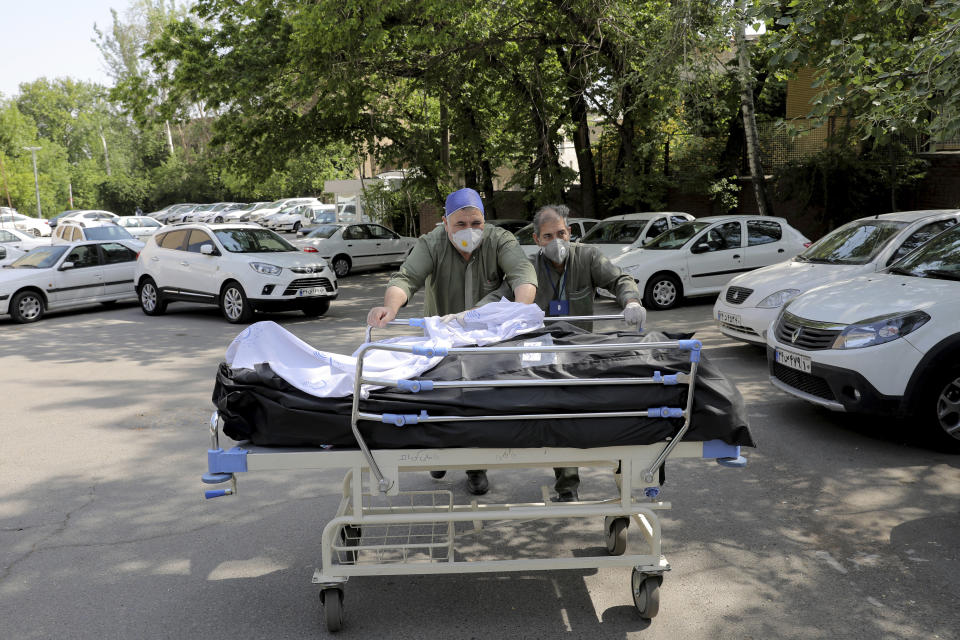 Hospital workers move two bodies of patients who died from COVID-19, at the yard of the Shohadaye Tajrish Hospital in Tehran, Iran, Sunday, April 18, 2021. After facing criticism for downplaying the virus last year, authorities have put partial lockdowns and other measures in place to try and slow the coronavirus’ spread, as Iran faces what looks like its worst wave of the coronavirus pandemic yet. (AP Photo/Ebrahim Noroozi)