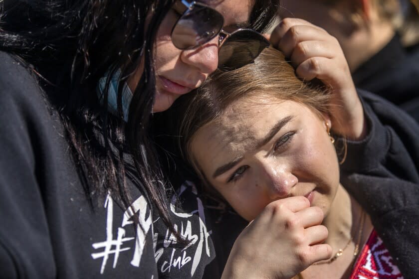 LOS ANGELES, CA - FEBRUARY 24: Milana Stryhun, 18, left, and Anastasia Zahrai, 19, right, gather along with over 100 members of the Ukranian community demonstrate at outside the Federal Building in Westwood on Thursday, Feb. 24, 2022 in Los Angeles, CA. (Francine Orr / Los Angeles Times)