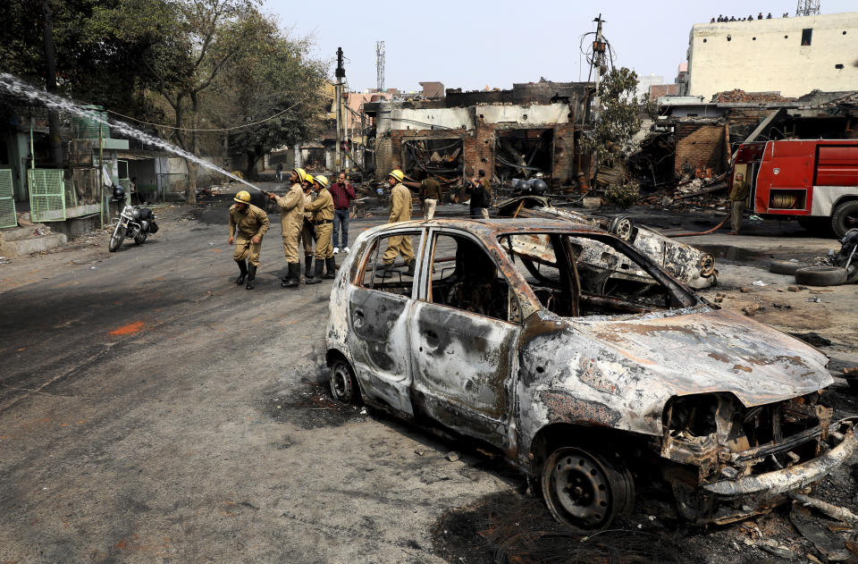 FILE - In this Wednesday, Feb. 26, 2020, file photo, firefighters douse a fire at Gokul puri tyre market which was burnt Tuesday in New Delhi, India. Indian police violated human rights during deadly religious riots in New Delhi earlier this year, Amnesty International said in a report released Friday, Aug. 28, 2020. It said police beat protesters, tortured detainees and in some cases took part in riots with Hindu mobs. Authorities say more than 50 people were killed when clashes broke out between Hindus and Muslims over a controversial citizenship law in February in the worst rioting in the Indian capital in decades. (AP Photo/Manish Swarup, File)