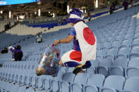 A fan of Japan collects garbages at the end of the World Cup round of 16 soccer match between Japan and Croatia at the Al Janoub Stadium in Al Wakrah, Qatar, Monday, Dec. 5, 2022. (AP Photo/Eugene Hoshiko)
