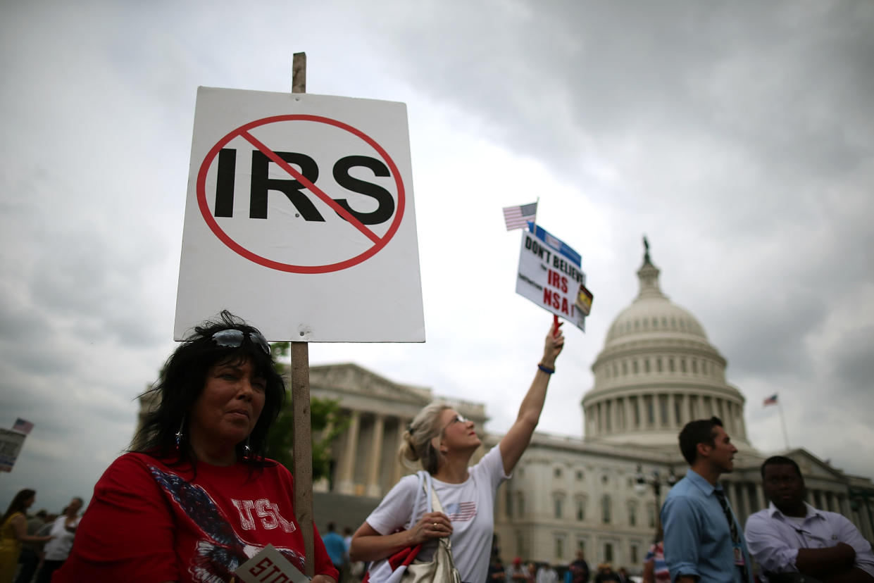WASHINGTON, DC - JUNE 19:  Nancy Riordan holds a sign while participating in a Tea Party rally at the U.S. Capitol, June 19, 2013 in Washington, DC. The group Tea Party Patriots hosted the rally to protest against the Internal Revenue Service's targeting Tea Party and grassroots organizations for harassment.  (Photo by Mark Wilson/Getty Images)
